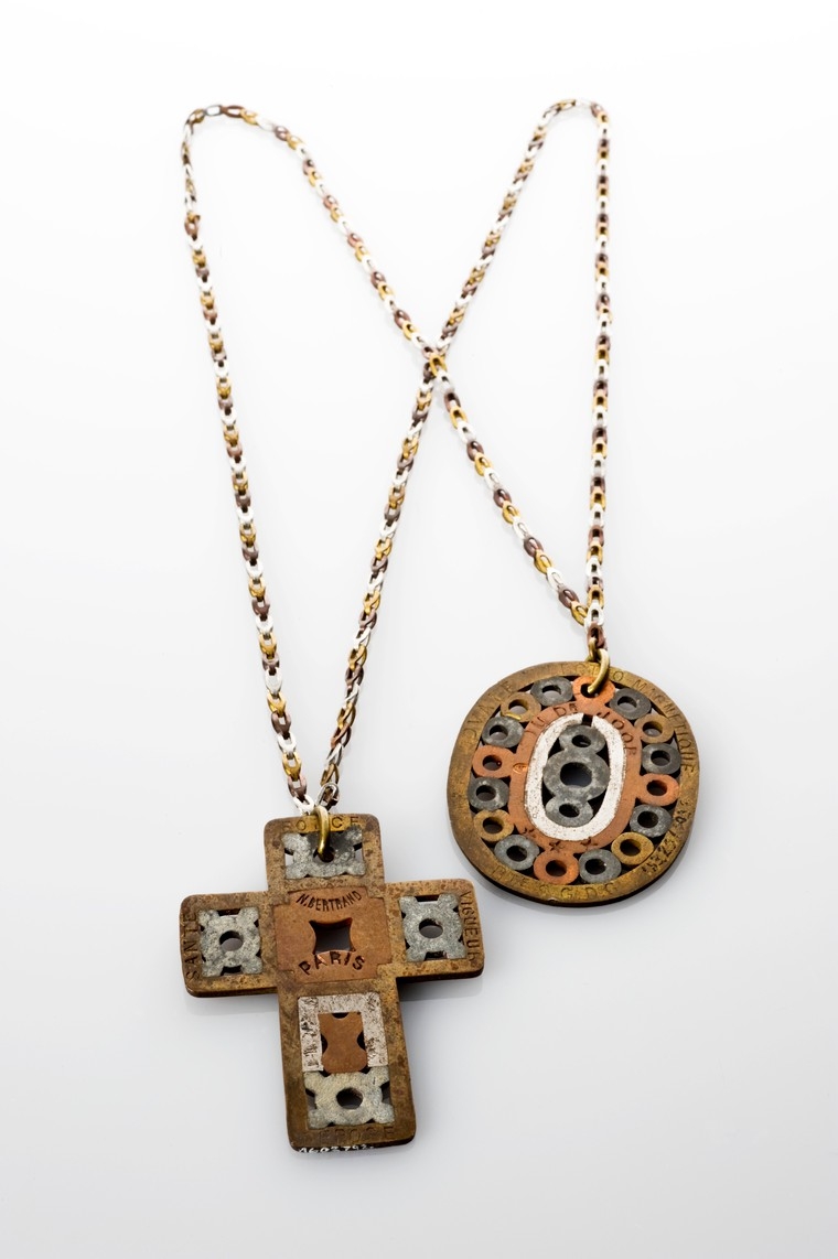 Image of a necklace with a cross-shaped and an oval-shaped amulet