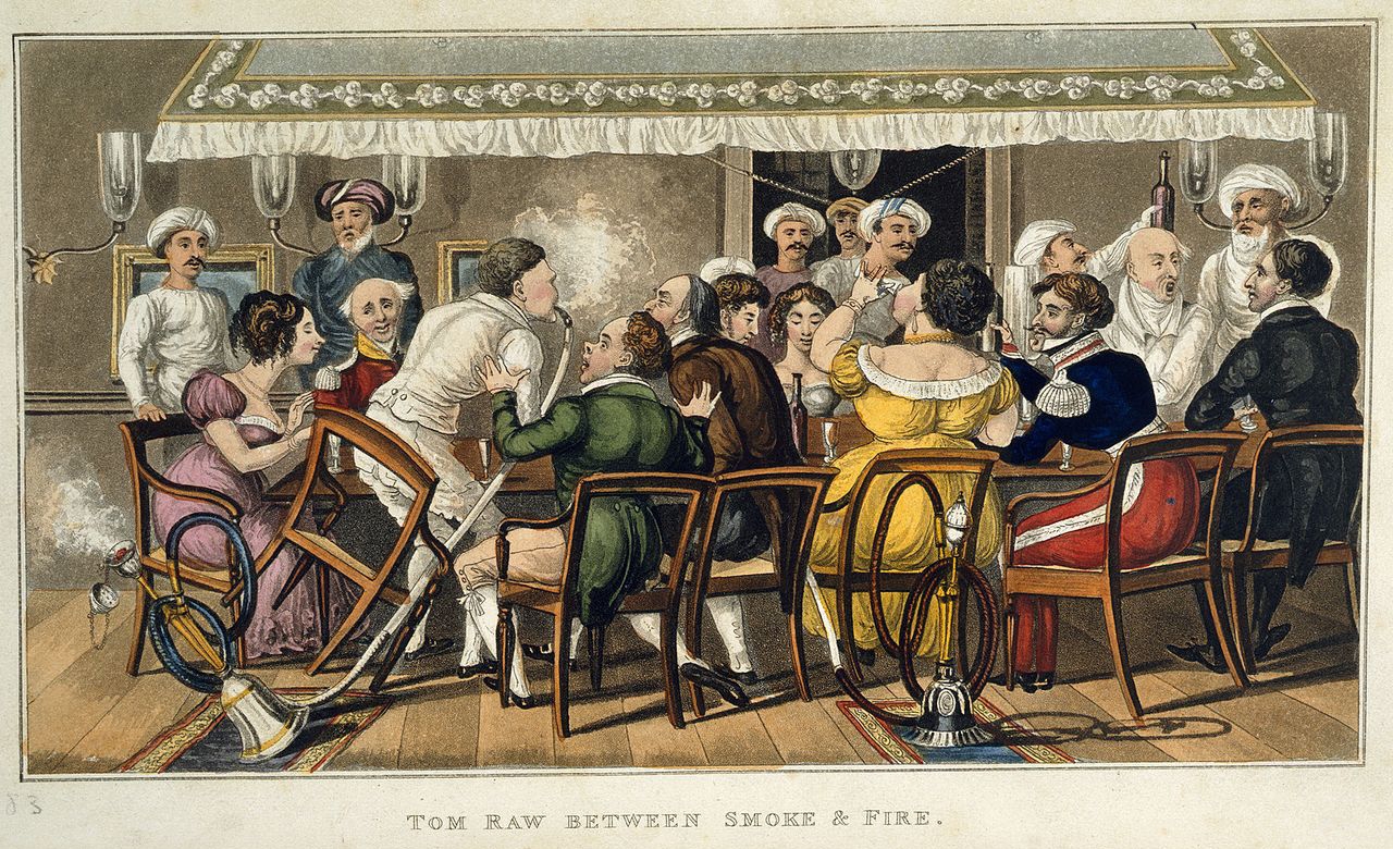 An animated group of European men and women seated around a dining table smoking hookahs and drinking wine attended by Indian servants. One man knocks over a hookah as he gets out of his chair.