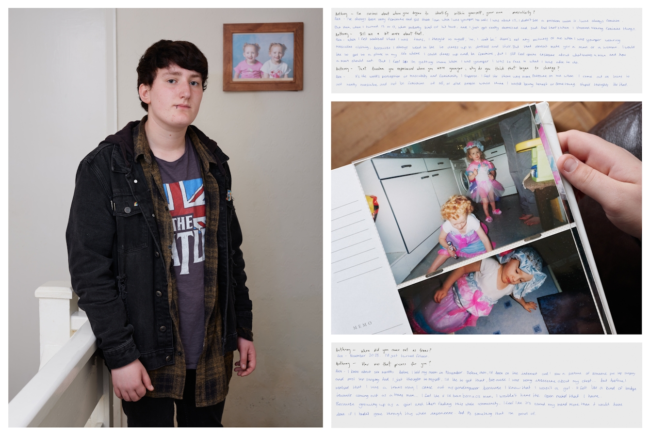 Photograph of an individual standing in an upstairs landing. They are looking straight to camera and behind them on the wall is a framed photograph showing 2 toddlers. To the right of this photograph is another photograph showing a hand holding a family photo of two toddlers in pink and blue outfits. Above and below this image are images of handwritten texts.