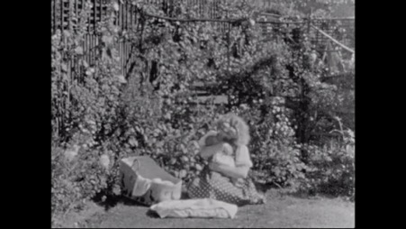 Image of a woman holding a baby in a garden.