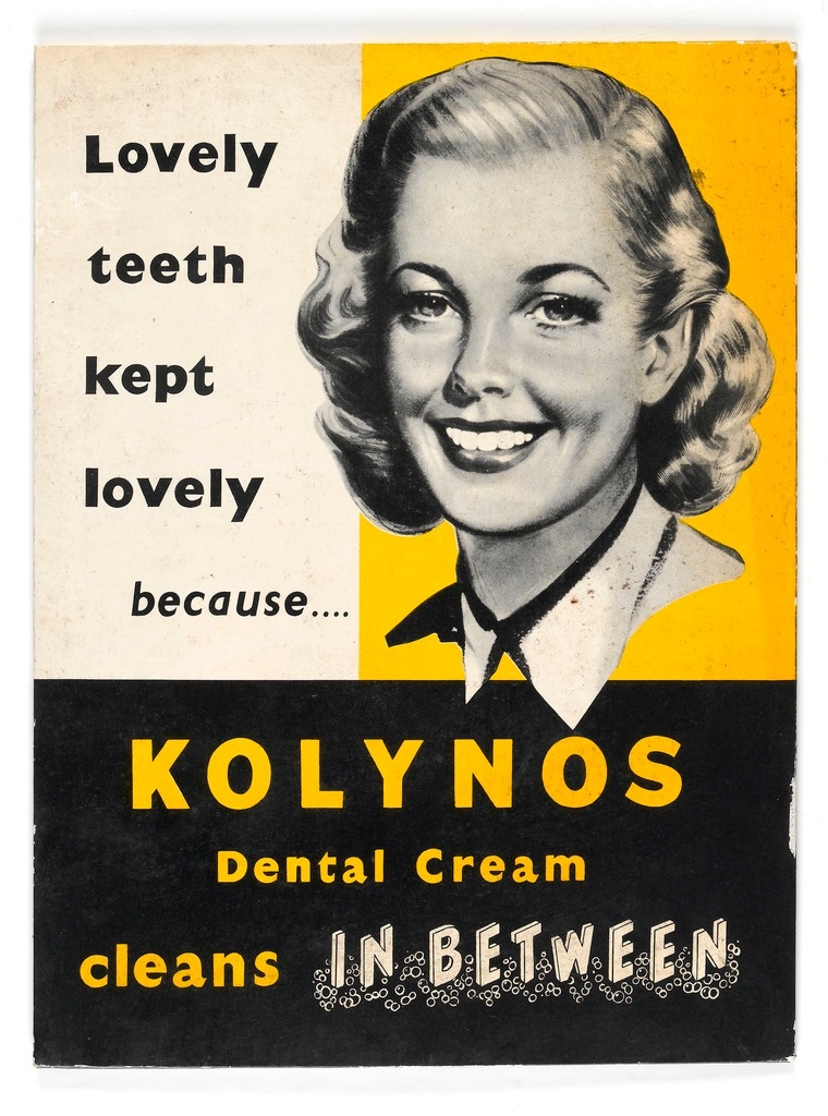 Black, white and yellow advert for dental cream featuring a smiling, young blonde woman with bright white teeth.