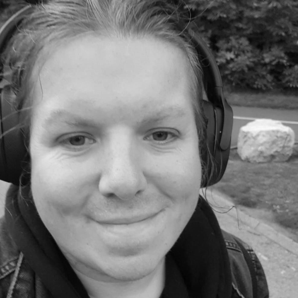 Black and white headshot of Jude Seal wearing headphones.