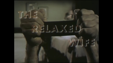 Still image from film of the title page with text 'THE RELAXED WIFE' and a close up of someone's hands gripping a black band of material so that the knuckles face the viewer