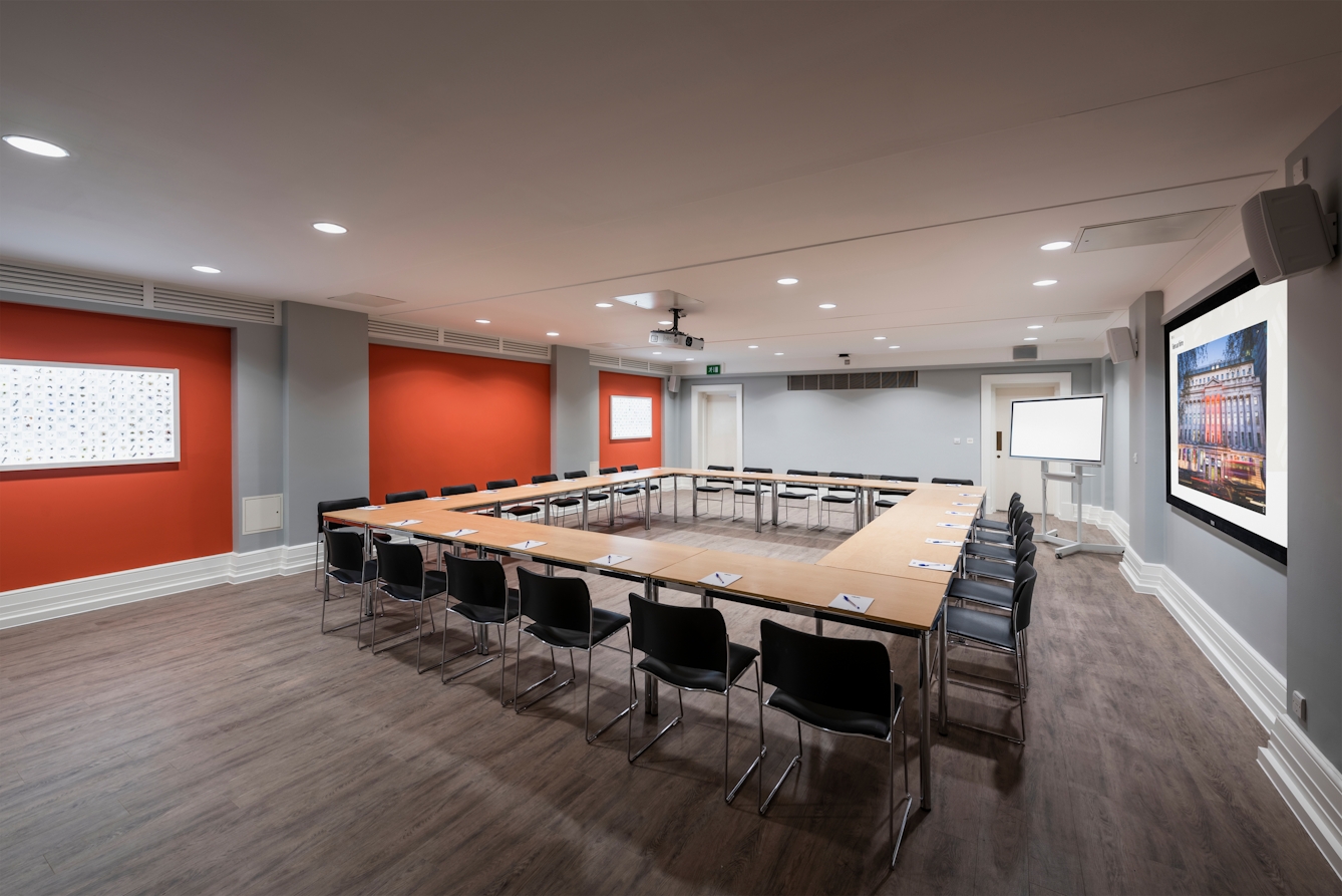 Photograph of the Burroughs room at the Wellcome Collection. 

Photograph shows a boardroom set-up and a presenting screen and whiteboard. 