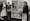 Black and white photograph of three nurses in uniform protesting about spending money on nuclear weapons rather than healthcare. They stand either side of a poster that reads "For the cost of one Trident we could have a decent National Health Service."