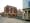 A contemporary photograph taken in Poundbury. Shows streets empty of people and cars, and a purpose-built new boxy houses with old-style columns.