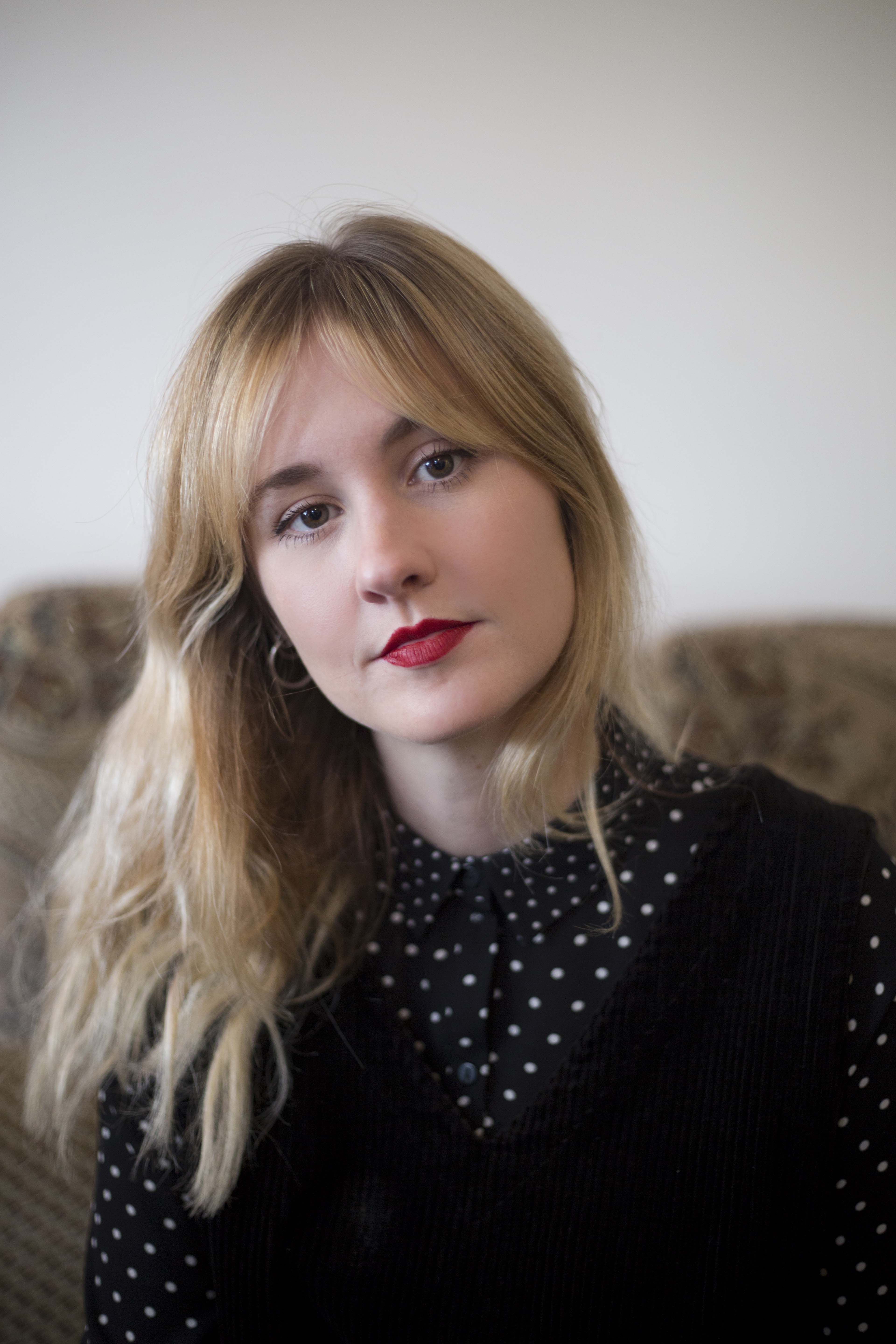 Colour photo portrait of young white woman with shoulder length blonde hair