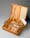 Image of an open wooden box with section dividers containing tubes and a bottle.