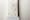 Photograph of a dusted fingerprint on a white door frame with a ruler scale beneath.