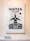 Photograph of a artwork banner hung in a gallery setting on a stained wood wall. On the banner is written the words 'water is life'. Below the words is an illustrated human figure in black and white, set in the context of land, sky and weather.