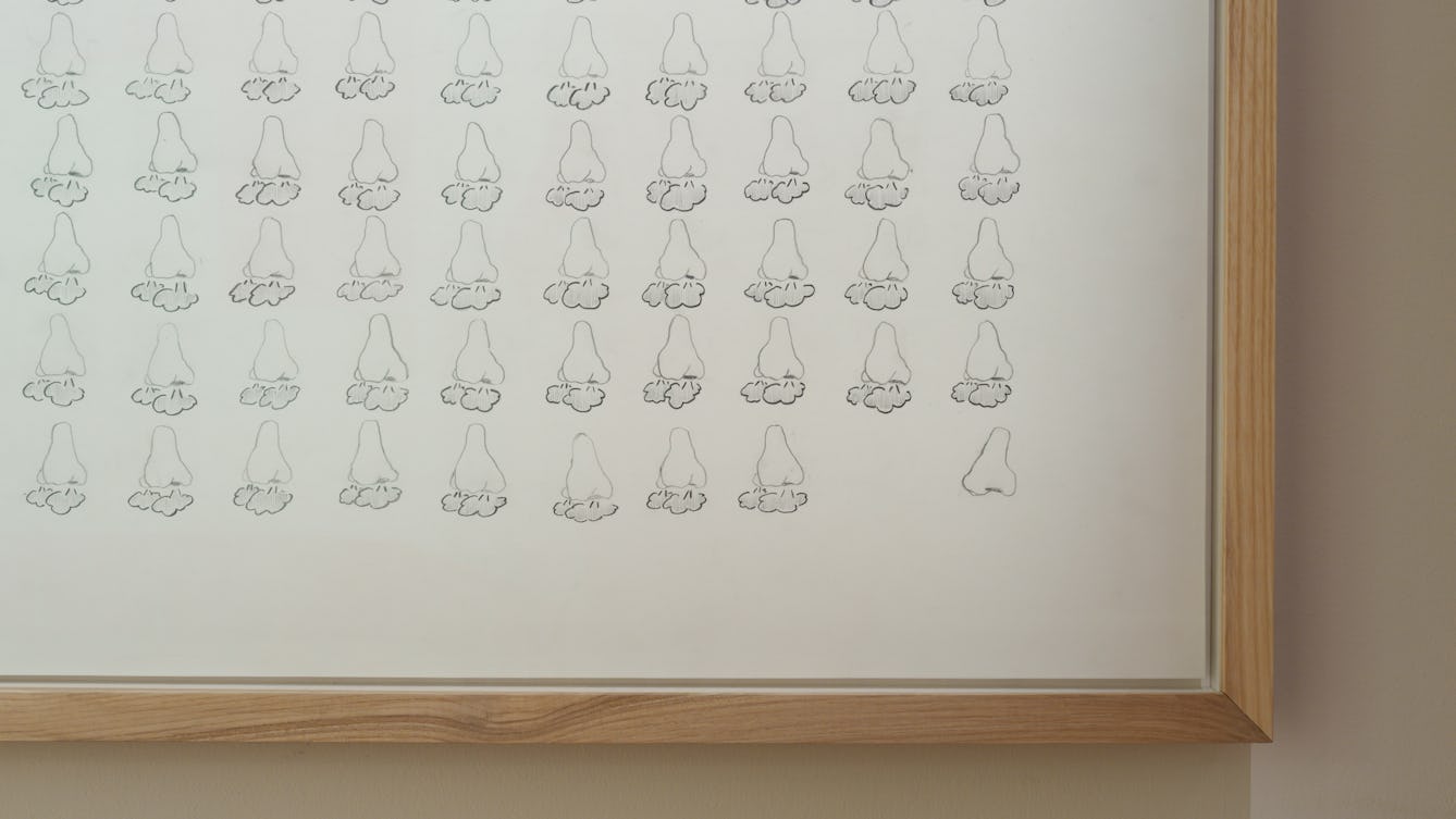 A framed drawing of rows of noses in a grid format. All the noses have clouds of air puffing out of the nostrils except the one in the bottom right corner which is slightly apart and drawn in profile with not puffing out air.