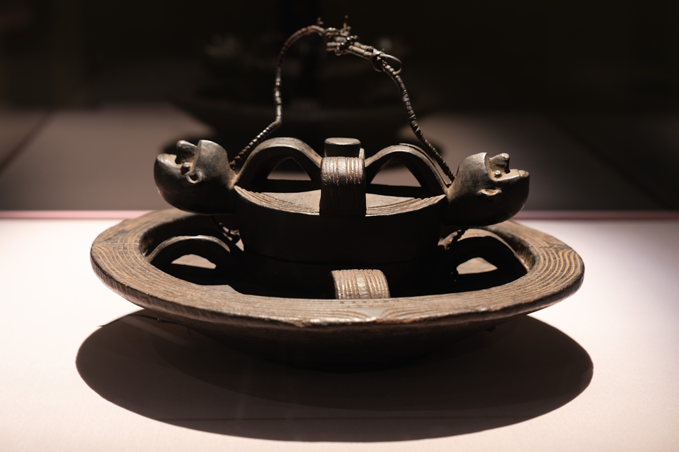 Photograph of a carved wooden bowl in a display case. 