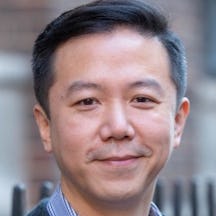 Headshot of a man with short hair smiling and looking to camera