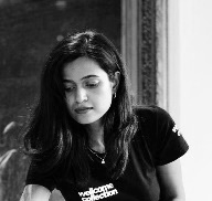 Black and white photo of the head and shoulders of a young woman with long black hair.