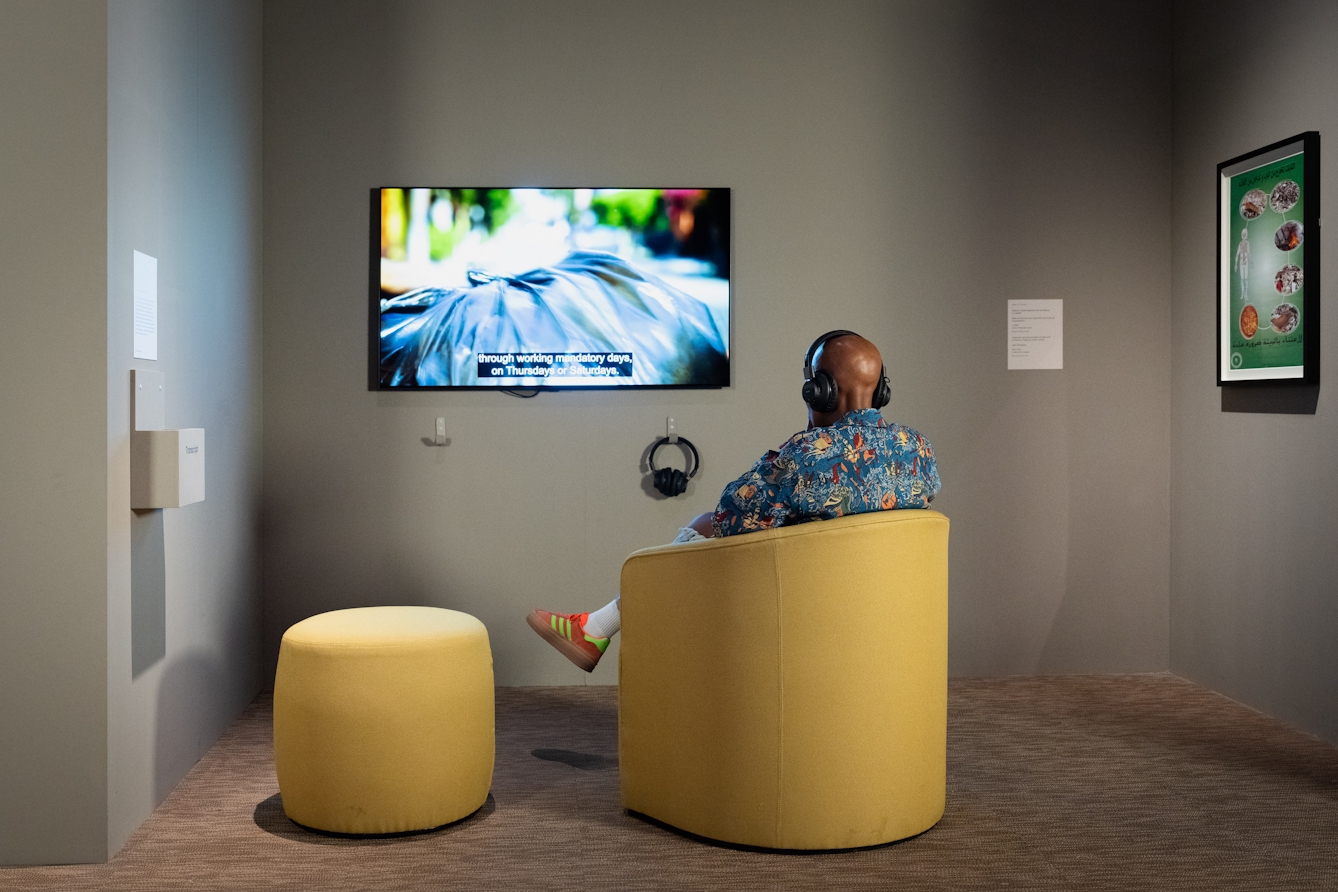 A photo of a person sitting down watching a film with headphones on