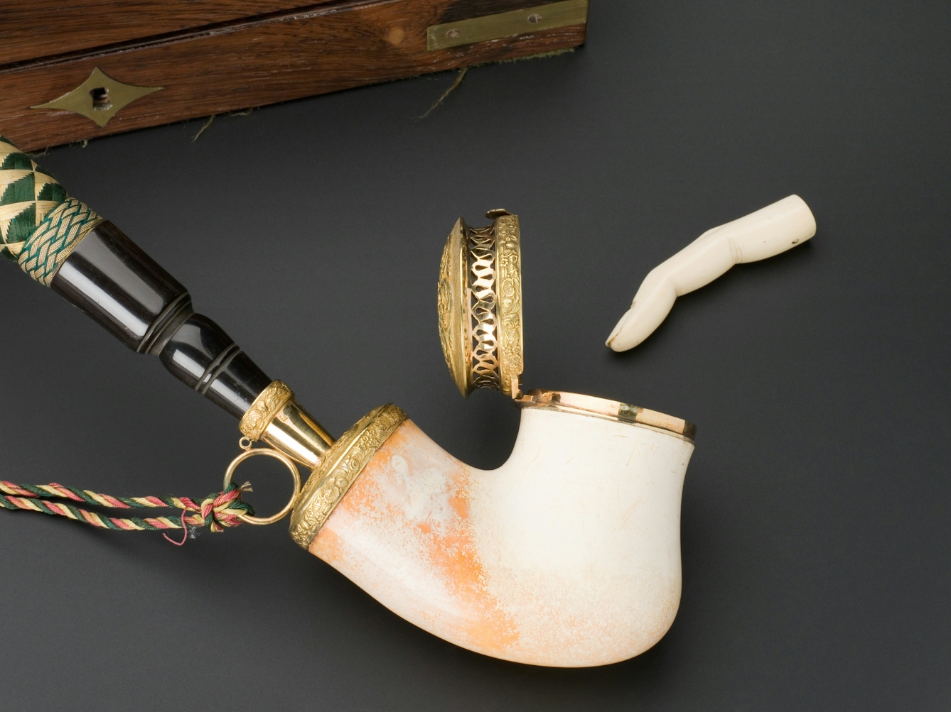 A large meerschaum pipe bowl and an ivory tamper in the shape of a finger (to pack tobacco into the pipe bowl).