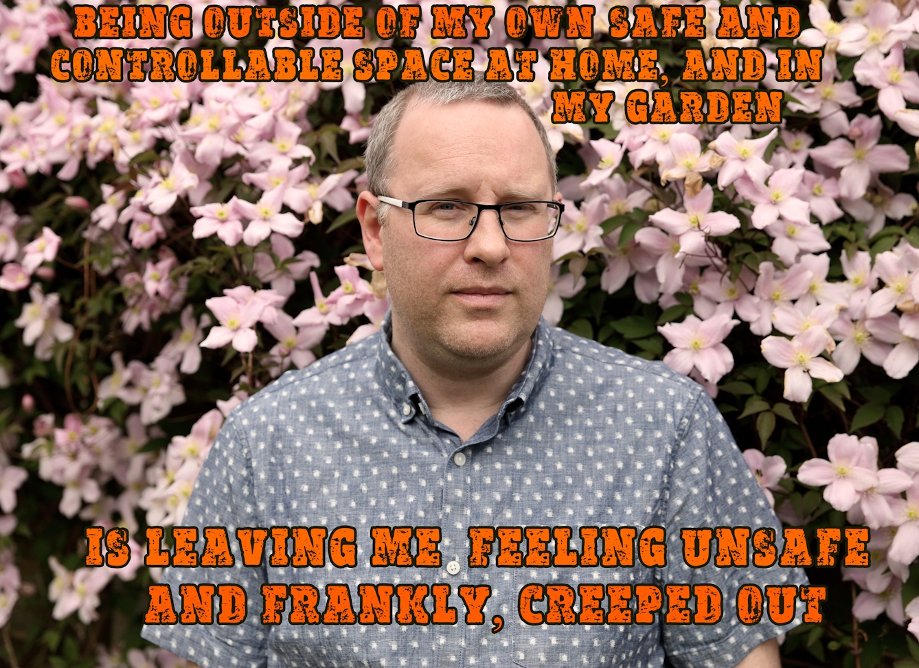 Photographic montage artwork showing a portrait of a man wearing glasses and a patterned blue shirt who is looking to camera. He is visible from the chest up and is looking to camera, head slightly turned to his left. In the background is a green bush covered in pink flowers. Digitally montaged on the image above his head, in an orange all caps font, are the words, "being outside of my own safe and controllable space at home, and in my garden", the text continues below his head, "is leaving me feeling unsafe and frankly, creeped out'.