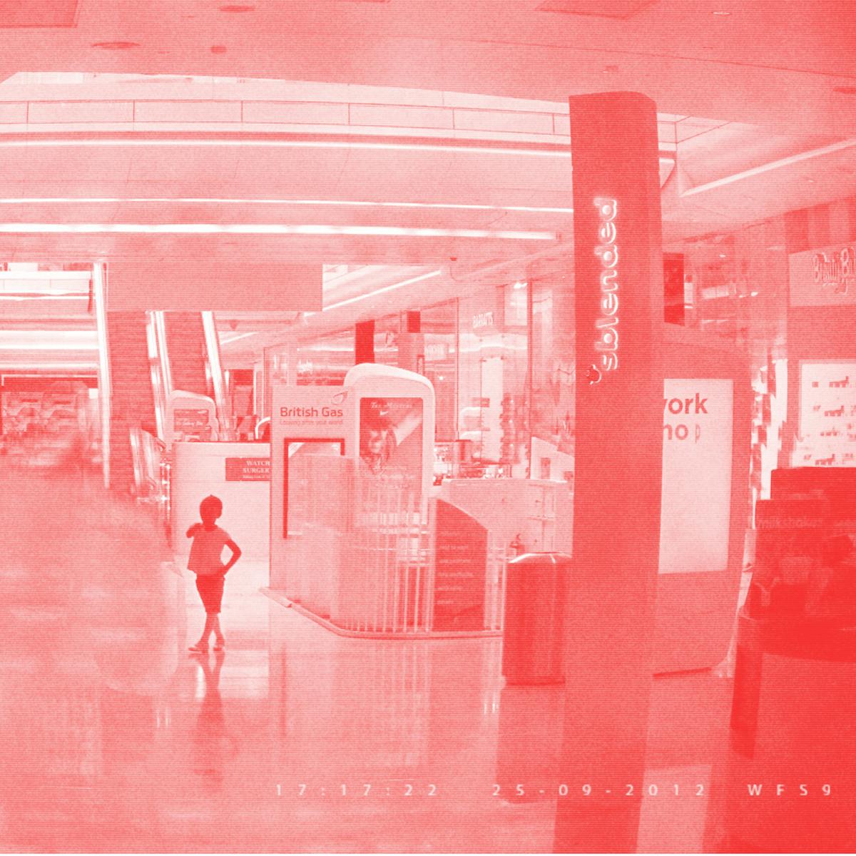 Pixellated photograph from a shopping mall security camera, where all adults have been crudely 'Photoshopped' out of the image, leaving one remaining child. The image has a red/pink tone applied to it.