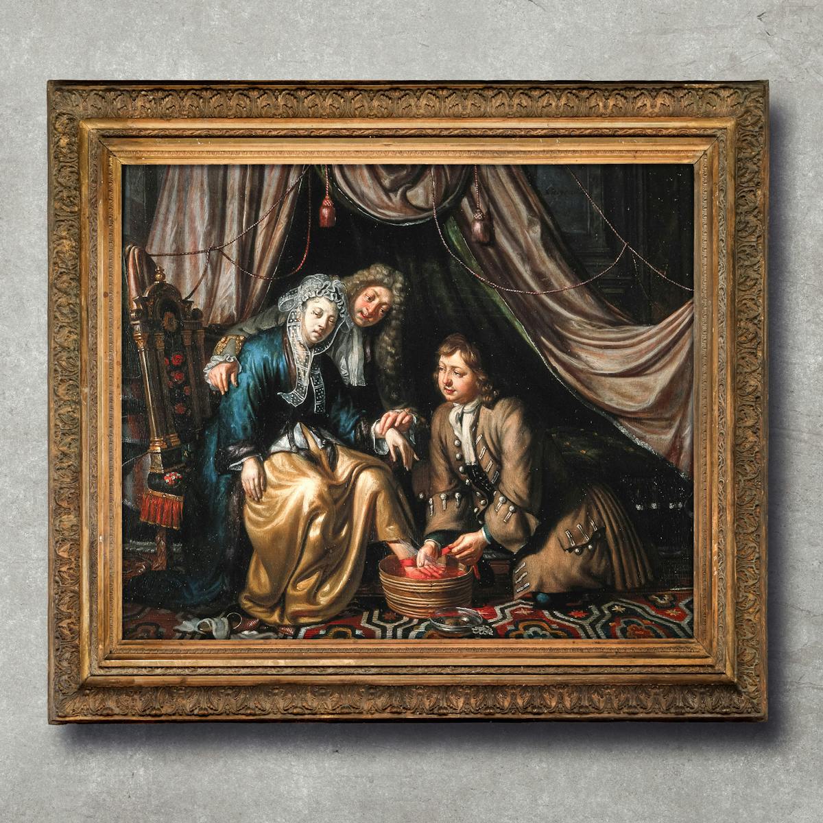 A photograph of an 18th century oil painting in a rusted gold metal frame displayed on a marble grey background. 

A woman patient, looking very pale, sits on a chair, left. Behind her, a doctor, wearing a wig, leans over her to take the pulse of her left hand with his left hand. Her left foot is placed in a tub of water and a young surgeon, kneeling on the right, lets blood from her left foot while holding a tourniquet around her ankle. The woman is obviously wealthy from her surroundings. She sits on an elaborately embroidered chair, a luxurious carpet covers the floor and silken drapes hang over her bed