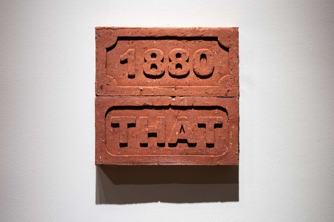 A photograph of a two bricks embossed with ‘1880’ and ‘THAT’.