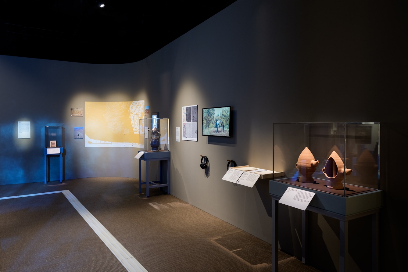 A display of pictures, maps, a jug anf film work.