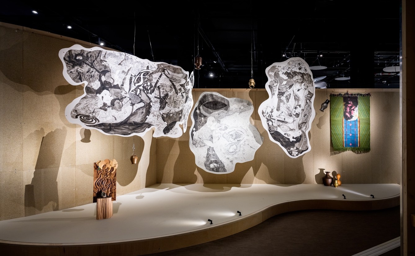 Three hanging ink drawings on cotton paper, suspended from the ceiling.