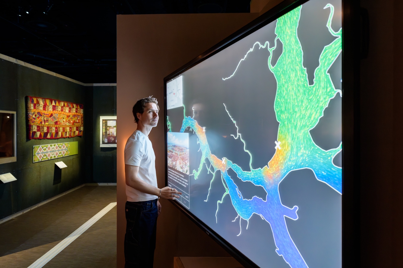 Person touching a large screen displaying a map of waterways.