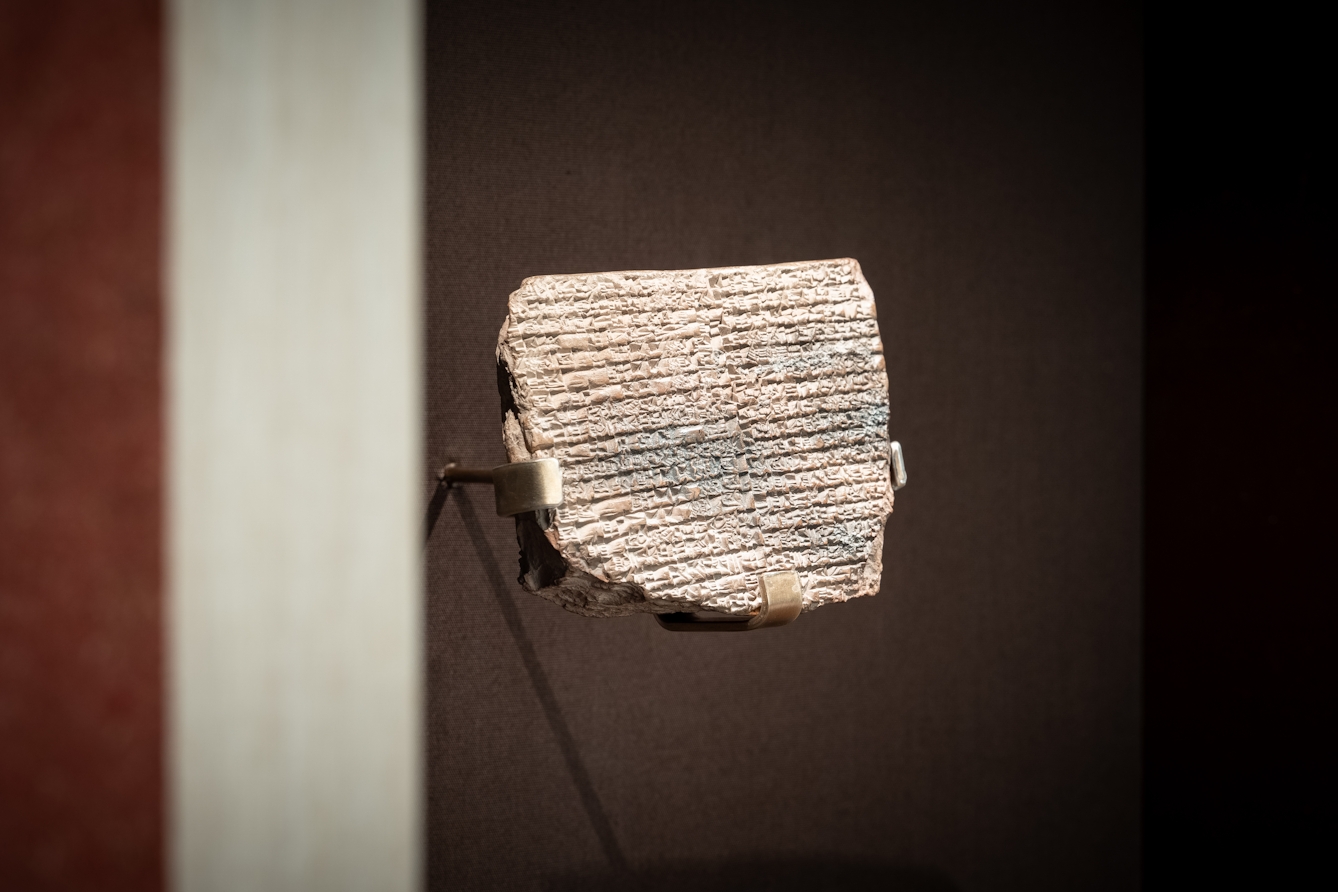Segment of an old clay tablet with inscriptions.