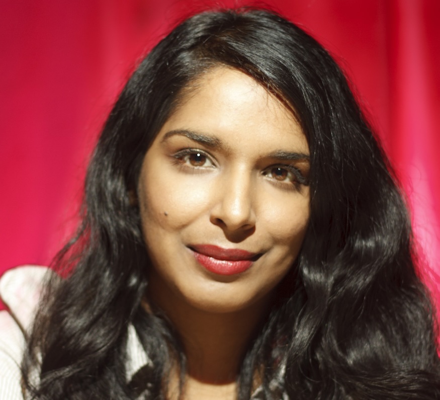 Head shot of a woman with long hair, smiling directly to camera.