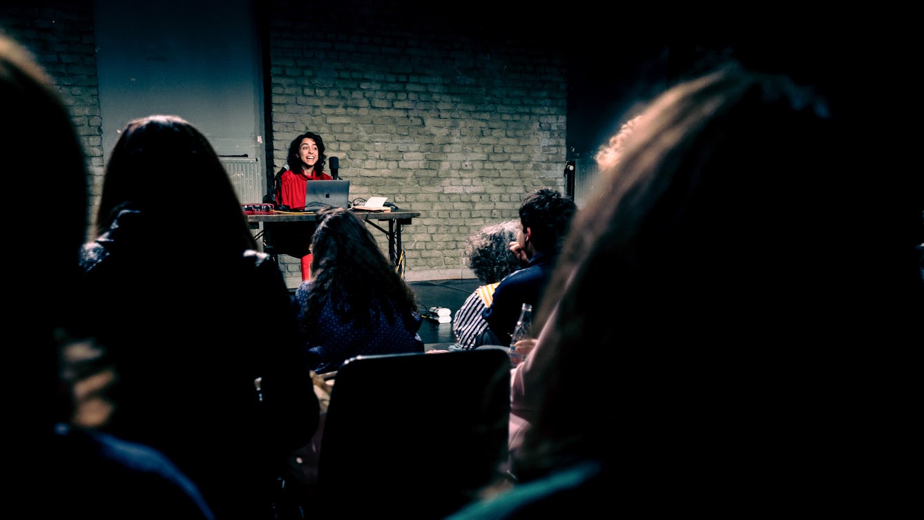 Bint Mbareh performing on a stage with instruments in front of an audience.