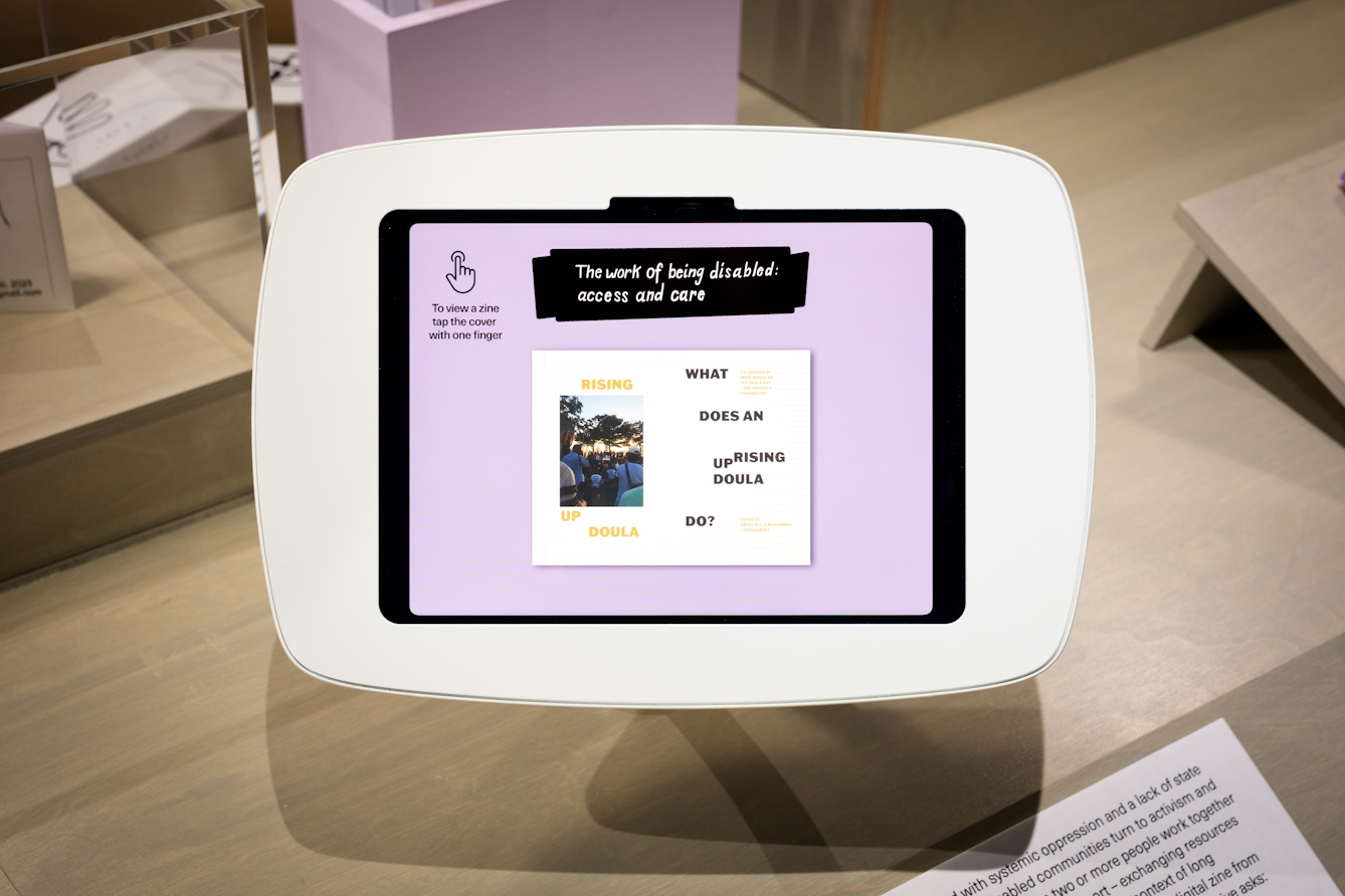 The zine 'Rising Up Doula' displayed on an tablet device in the gallery.