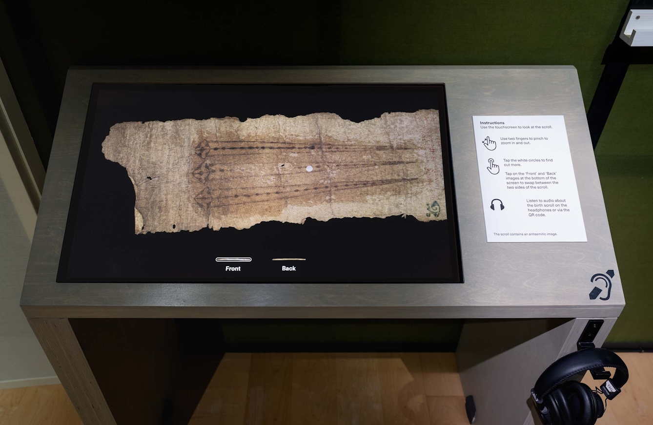 Interactive display screen showing a medieval scroll in the exhibition 'Expecting: Birth, Belief and Protection'.