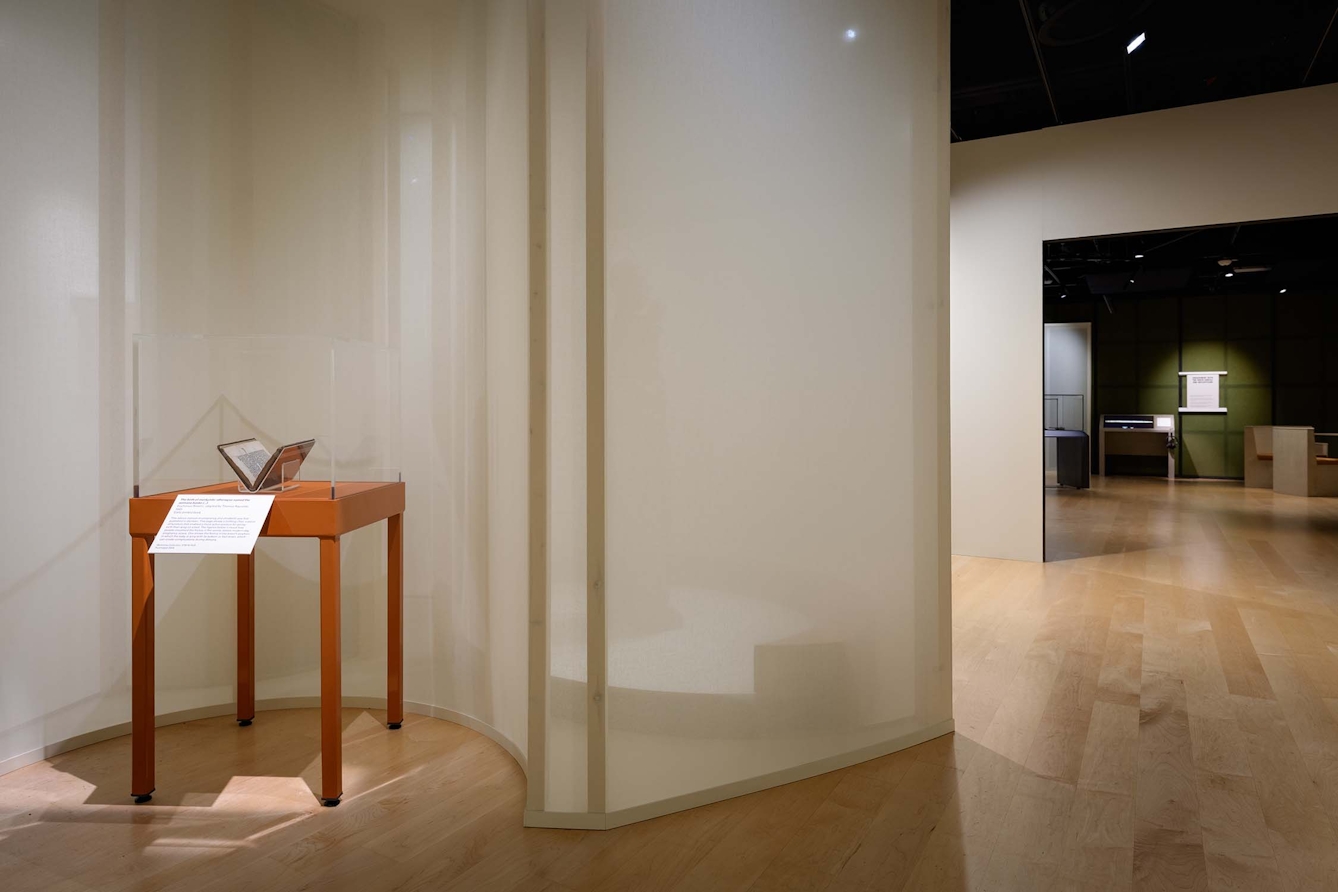 A glass and wood display case in an exhibition gallery
