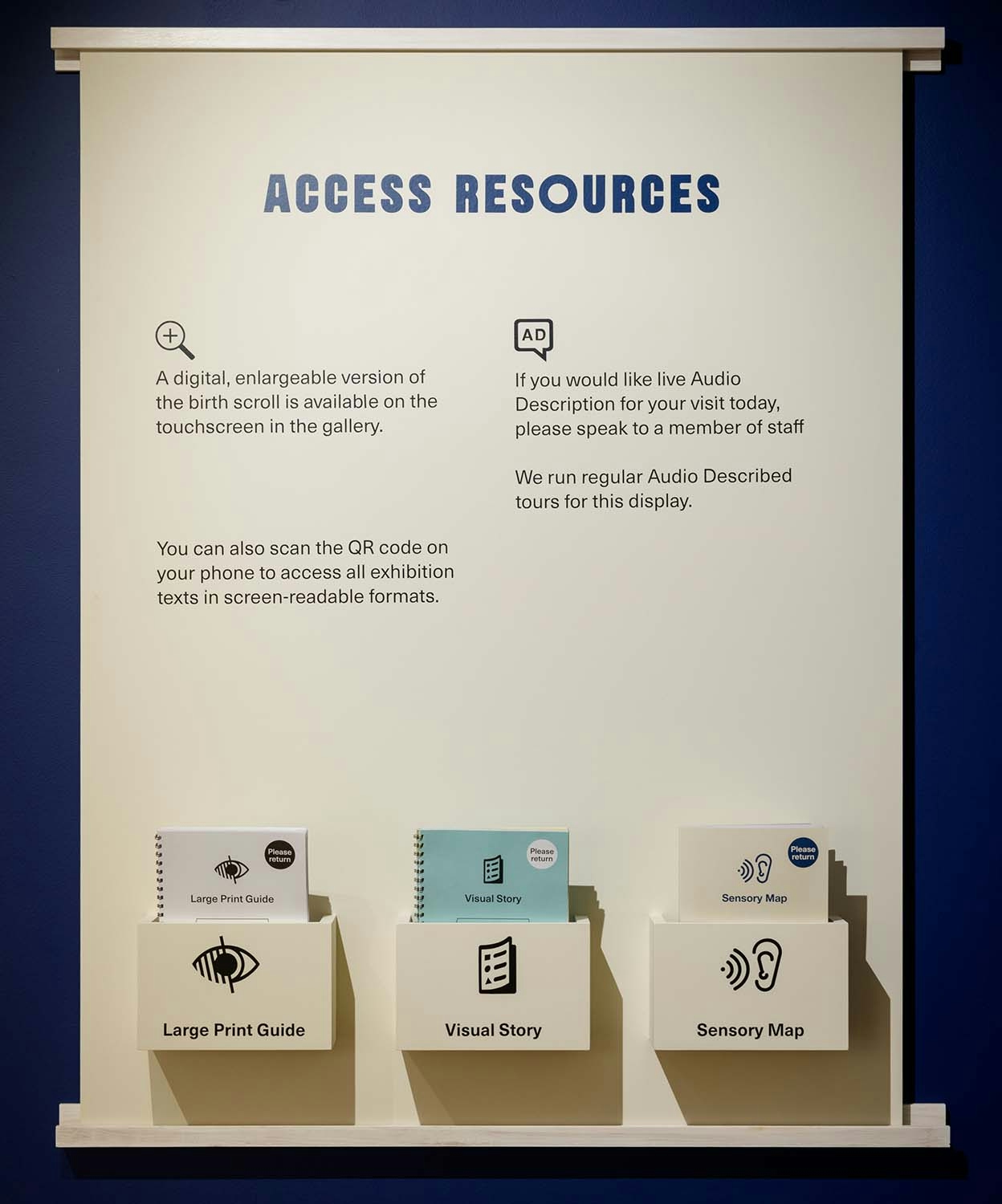 A wall display for access resources with three pamphlet boxes holding guides and maps.