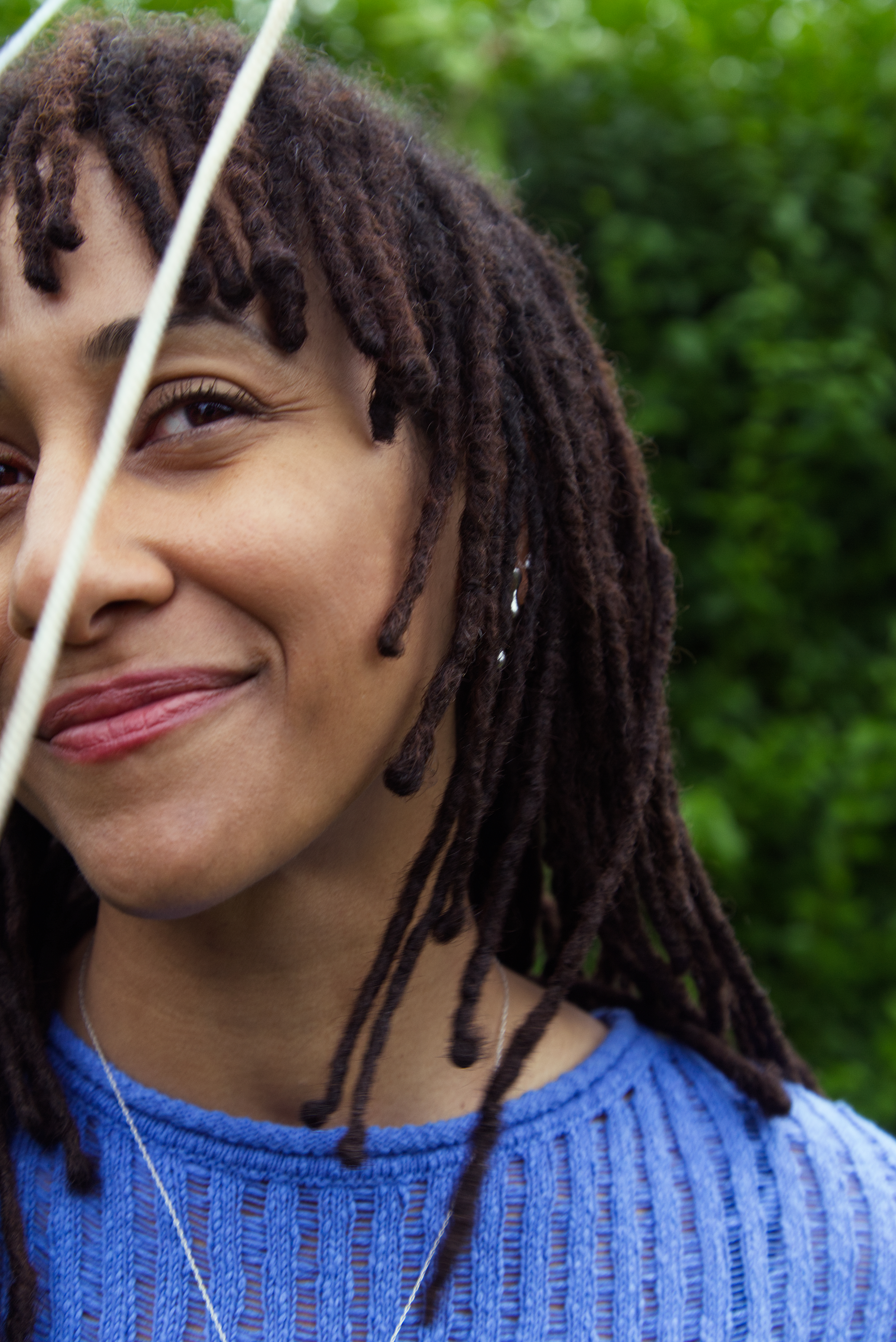 Black and white photograph of the head and shoulders of a young woman. She is smiling and looking directly at the camera.