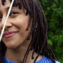 Black and white photograph of the head and shoulders of a young woman. She is smiling and looking directly at the camera.