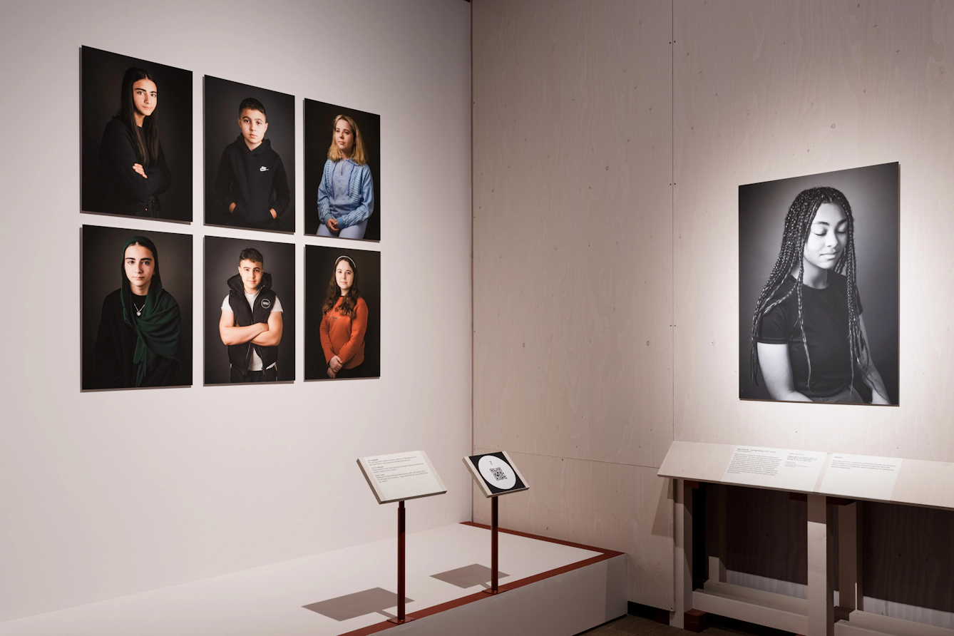 Six portraits of young people are on the left, while a large black and white portrait of a teenager is on the right.