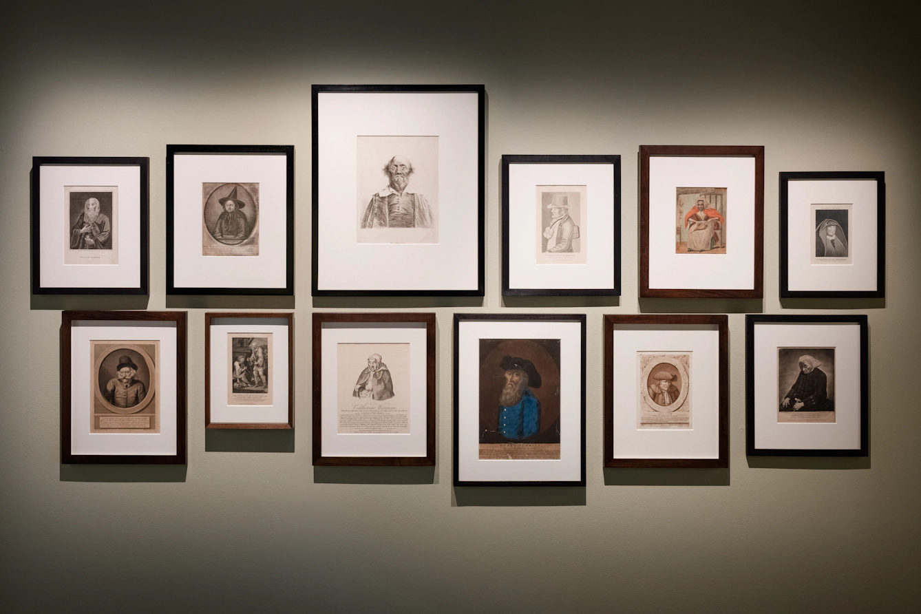 Gallery wall of painted and illustrated portraits.