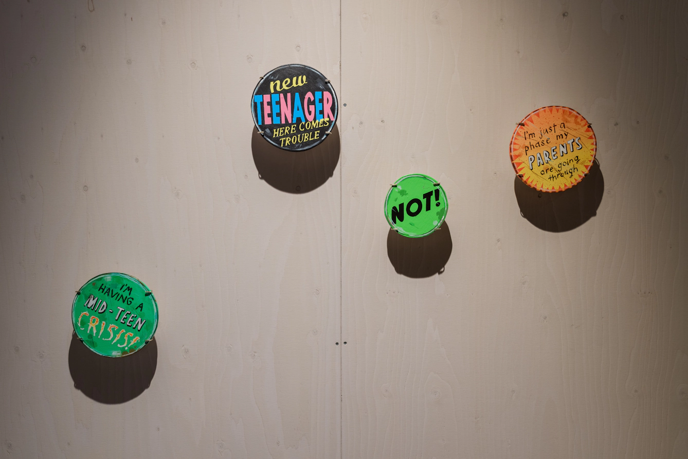 Colourful badges with slogans about adolescence.