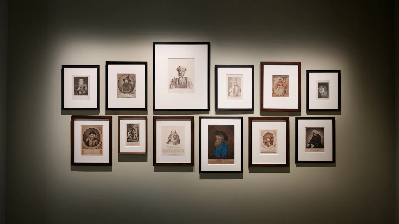 Gallery wall of painted and illustrated portraits.