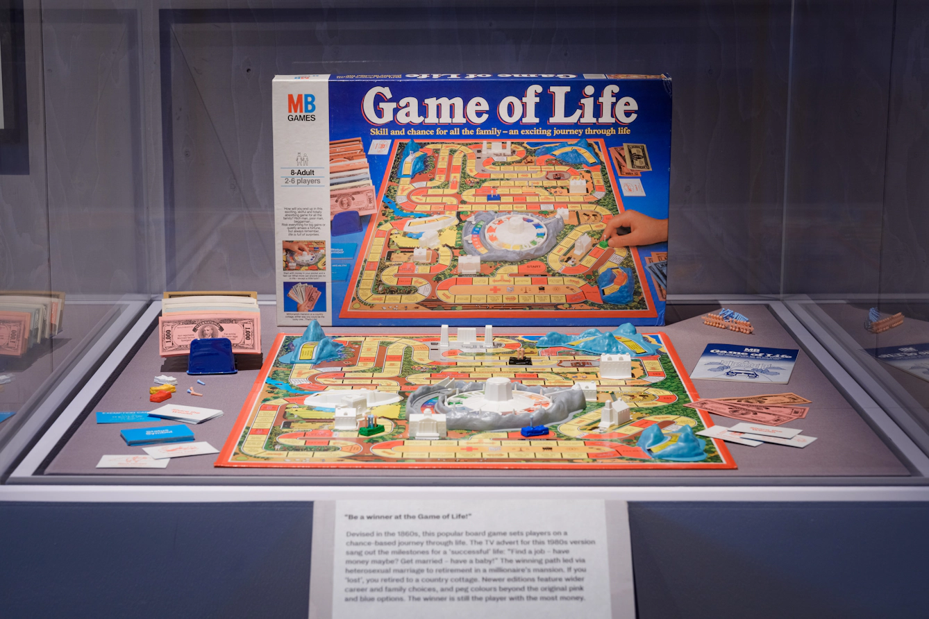 A colourful board game is laid out with its box propped up behind it.