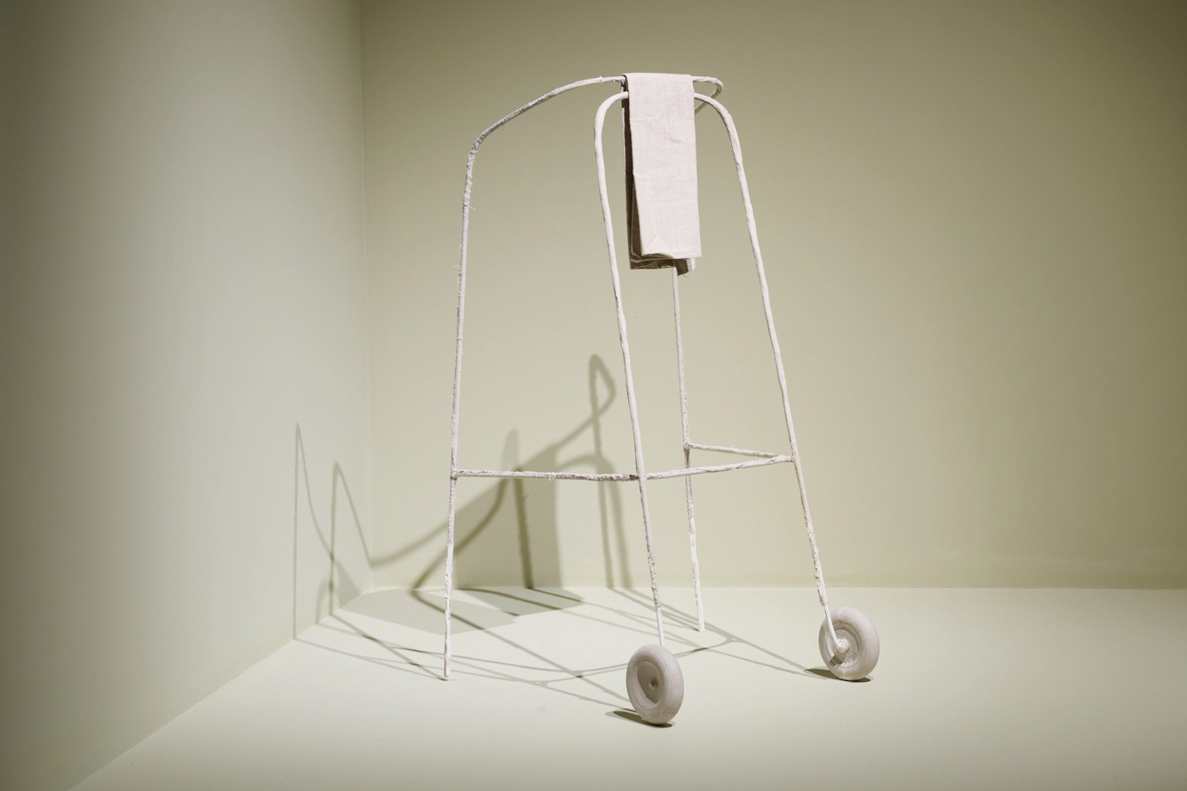 A fragile white zimmer frame with a white cloth folded over the front