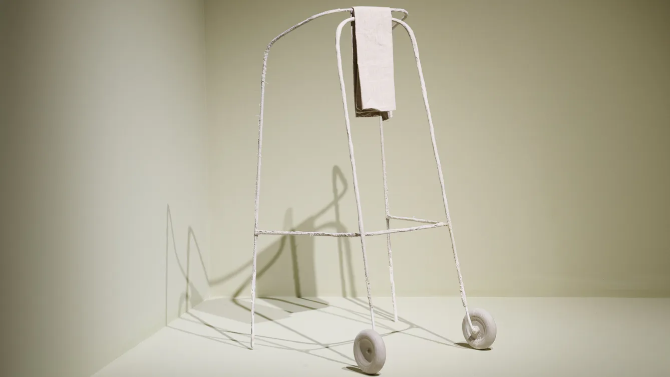 A fragile white zimmer frame with a white cloth folded over the front
