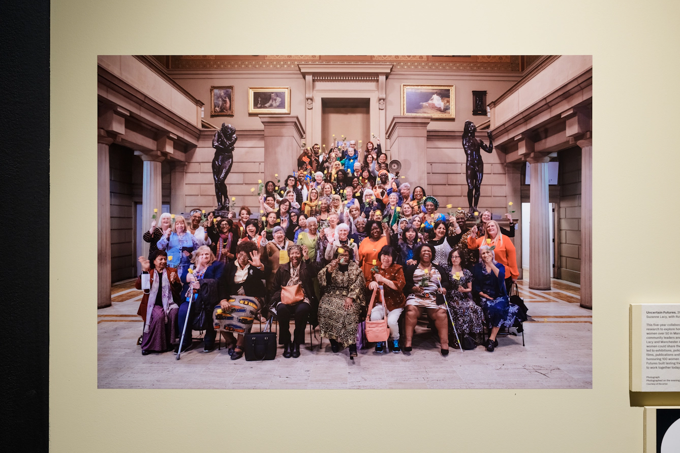 A large group of women stand at the bottom of a set of stone stairs.