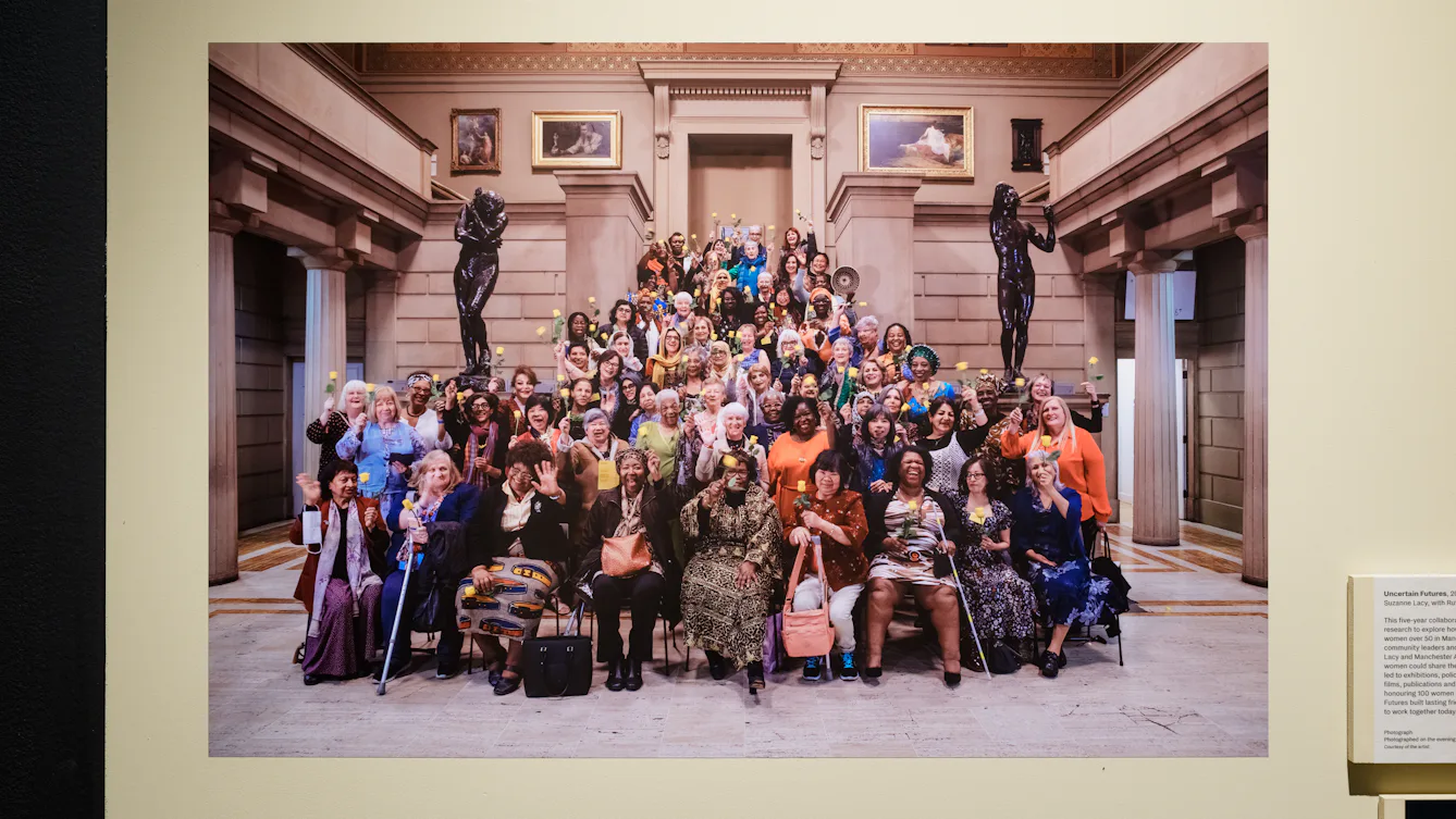 A large group of women stand at the bottom of a set of stone stairs.
