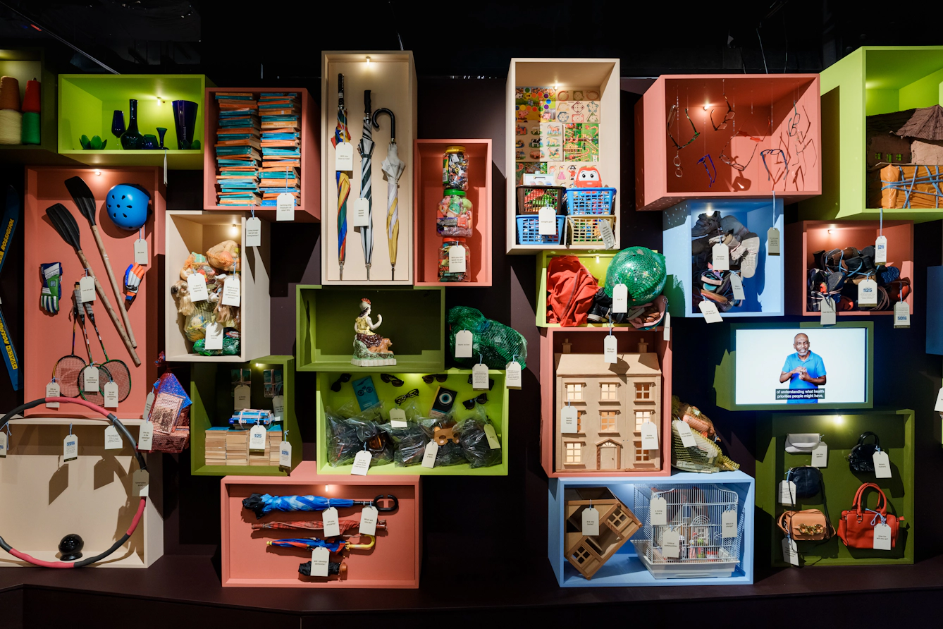 Colourful boxes are filled with miscellaneous objects, with labels hanging off them.