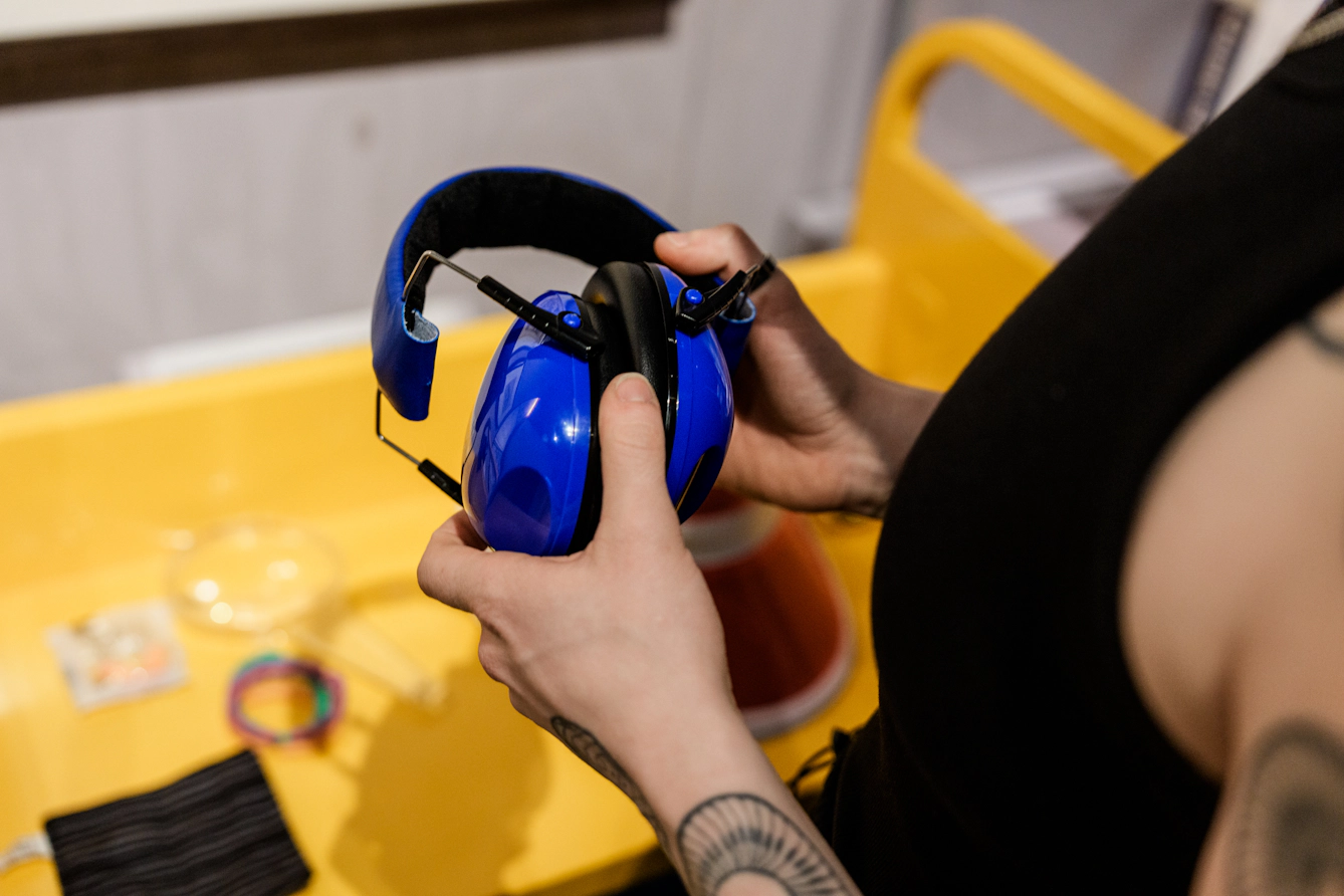 A visitor picks up a pair of ear defenders.