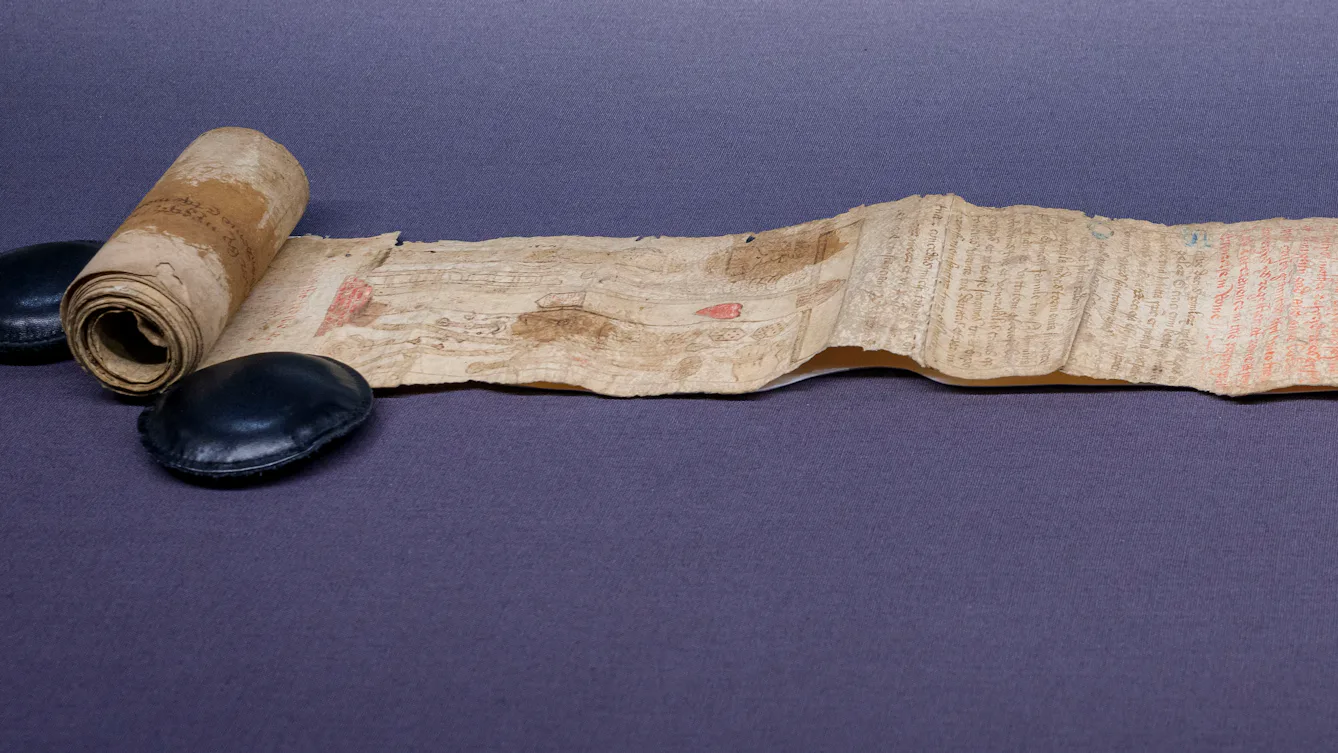 A partially unrolled parchment scroll with faded text, images and stains on its surface, from c1500 CE. Featured in an exhibition at Wellcome Collection: 'Expecting: Birth, Belief and Protection', 24 October 2025 – 19 April 2026.