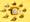 Photograph of a yellow rotary dial telephone surrounded in a circle by 8 specimen bottle containing a yellow liquid which get lighter in hue as you travel clockwise around the circle. The whole scene has been photographed against a bright solid yellow background.