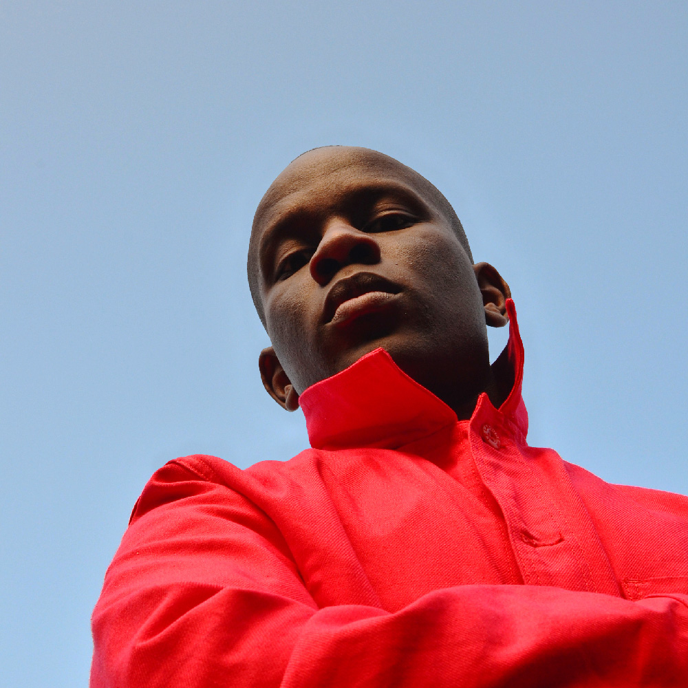 Photograph of Love Ssega looking down at the camera